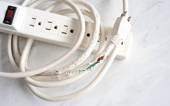 a power strip with a chewed and frayed wire
